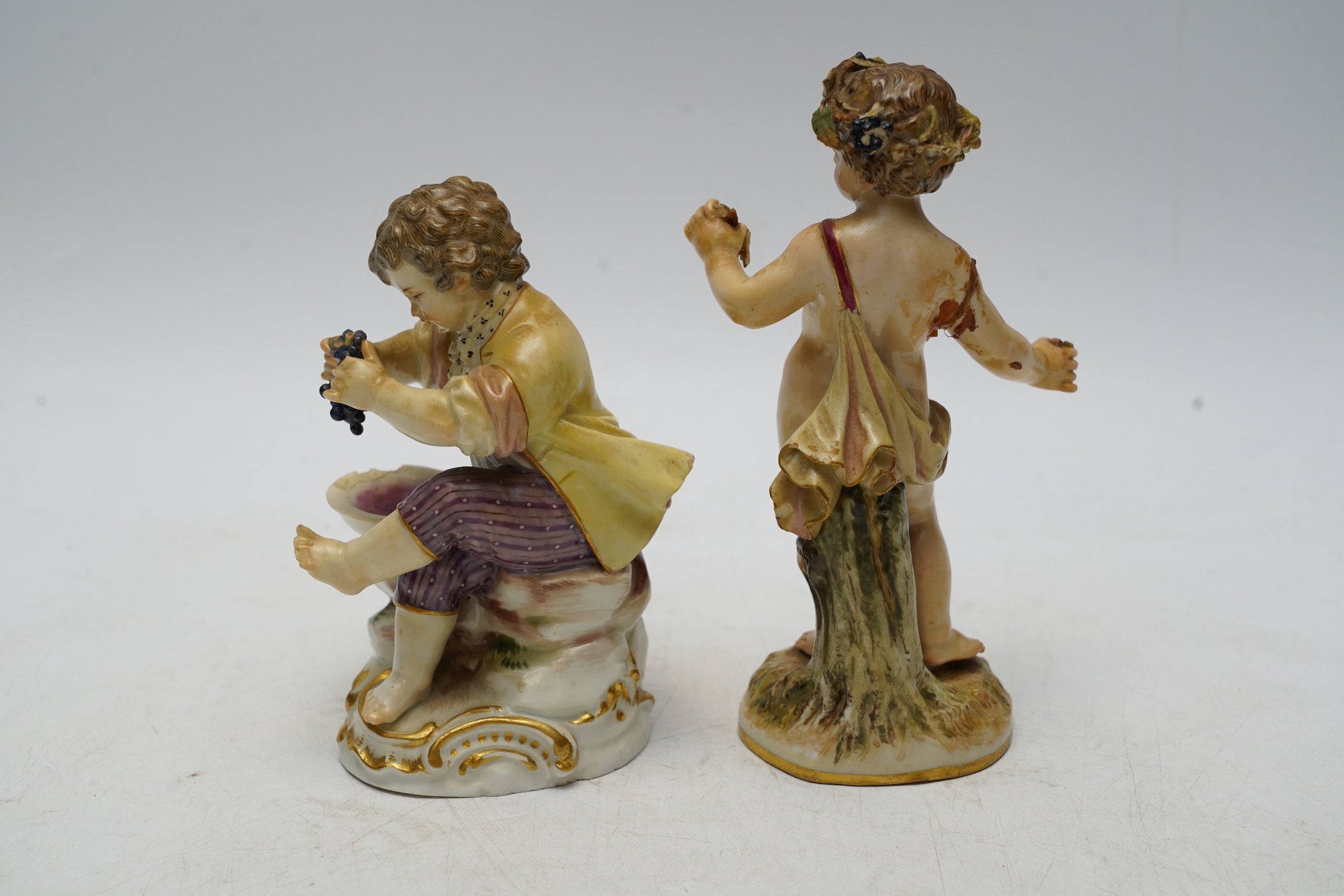 Two Meissen porcelain figures, boys with grapes, largest 13cm high. Condition - poor